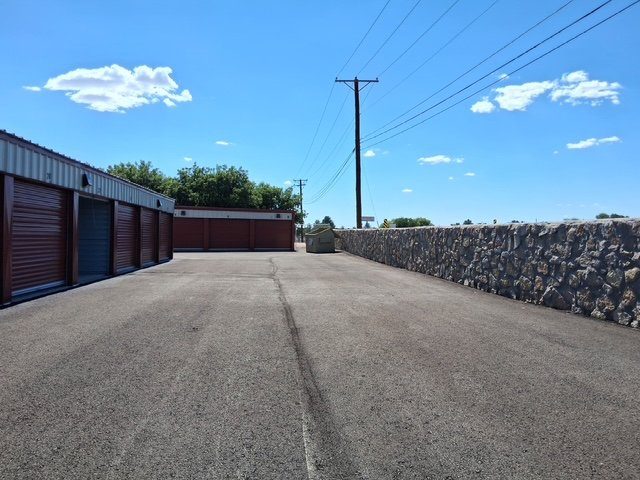 The walled, secure perimeter at Canutillo Self Storage with a solid rock boundary wall.