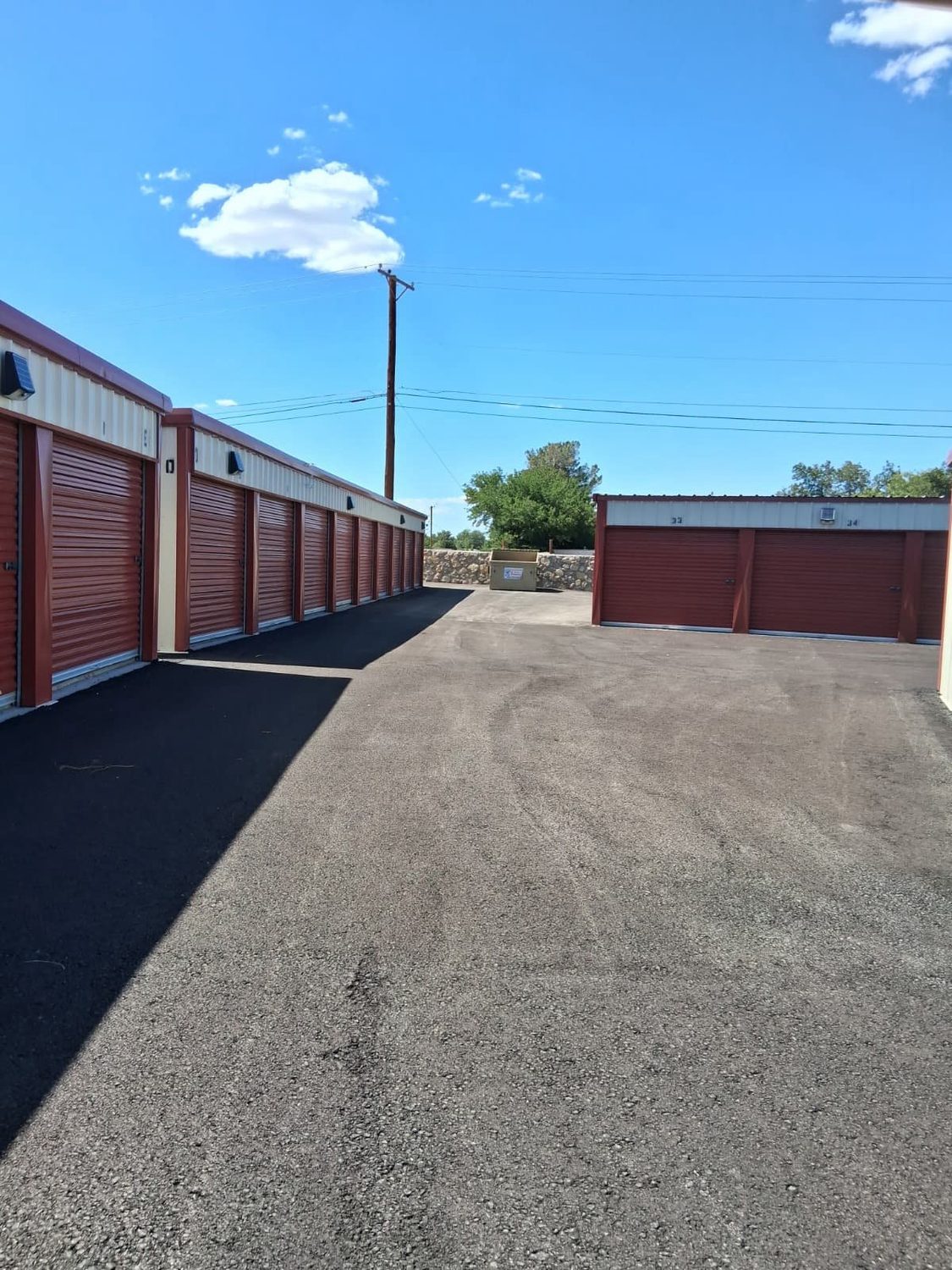 A wide open paved drive with drive-up storage units on both sides at Canutillo Self Storage.